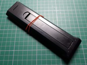Rubber band holding battery cover on TV remote