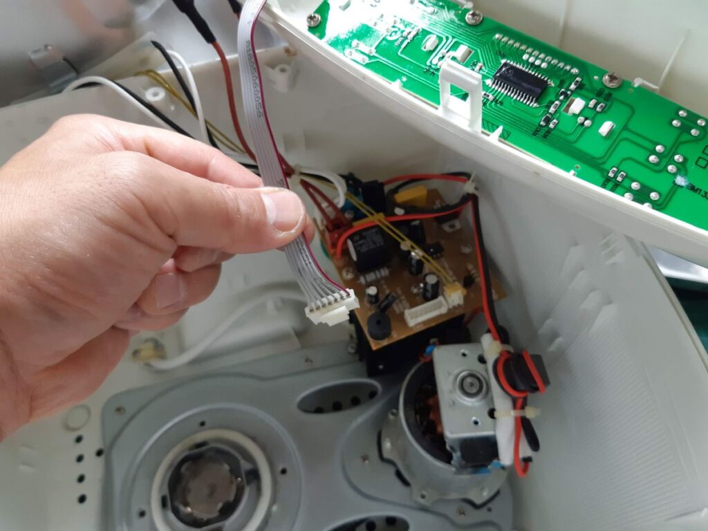 Reattaching the control panel to the control electronics inside the bread maker.